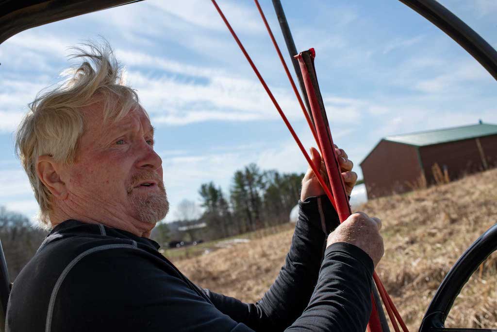 Vest drives in his off-road vehicle and collects poles on his land in Stewart, Ohio, on March 11, 2022. With 80 acres of land to look after, this vehicle provides quick and easy transportation, including to some of the traps around his property.  