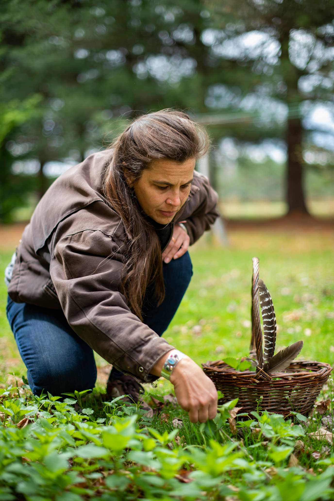 Quinn picks stinging nettle from her back yard in The Plains, Ohio, on April 1, 2022. Quinn’s backyard often serves as a source of materials for her crafts. Here she collects herbs for teas and even taps the trees for syrup.    